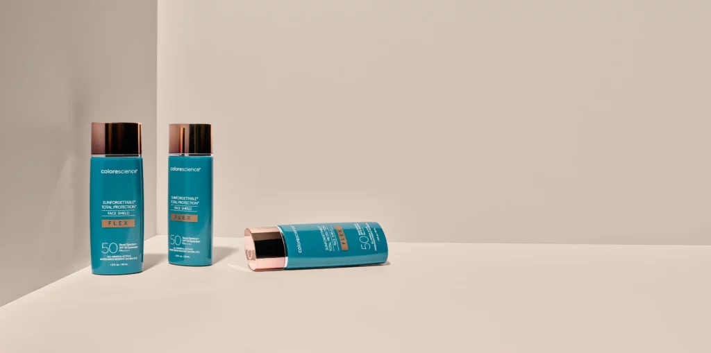 Hudpleie og solkrem fra Colorescience på en beige hylle
